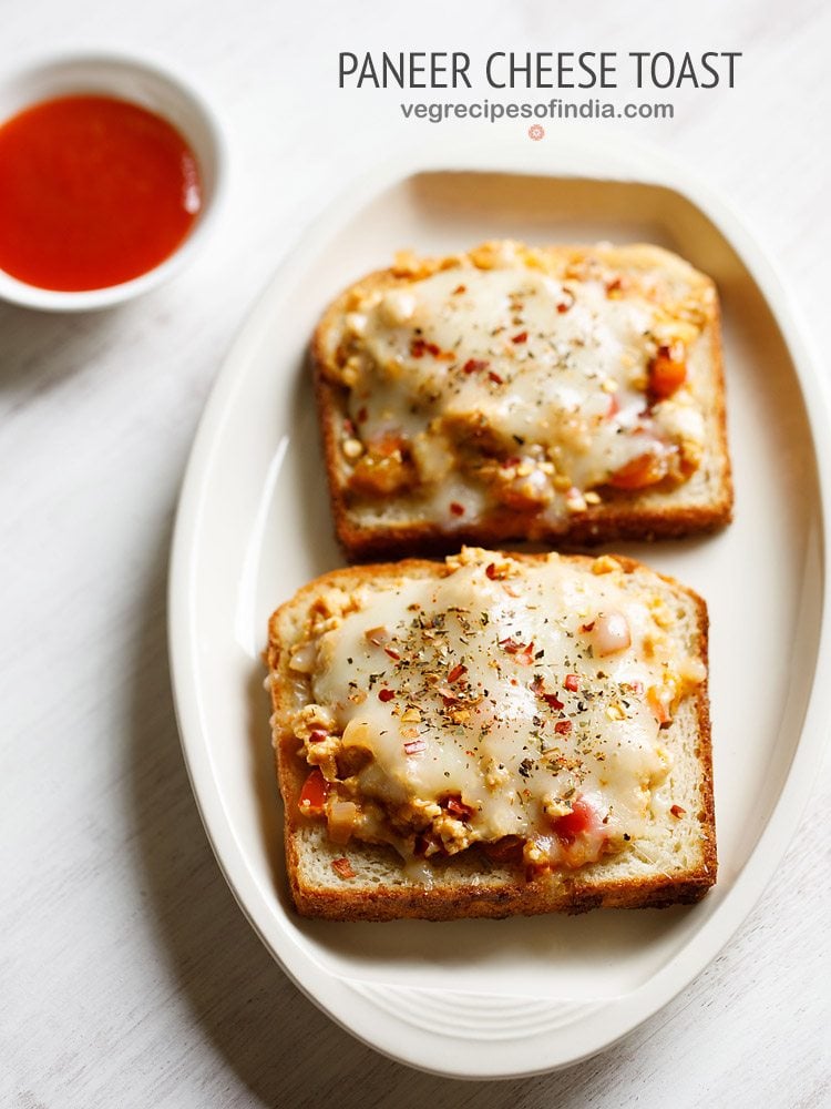 paneer toast served on a white platter with a small bowl of tomato ketchup kept on the top left side and text layovers.