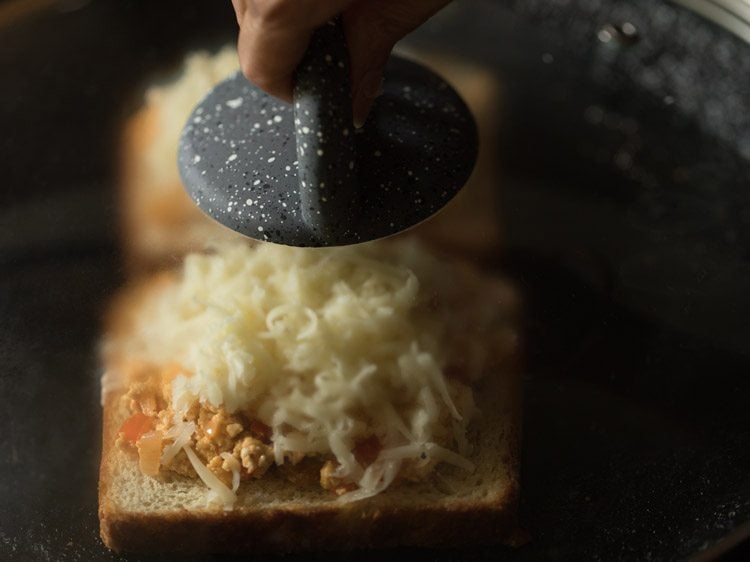 cooking the toasts on the pan by covering them. 