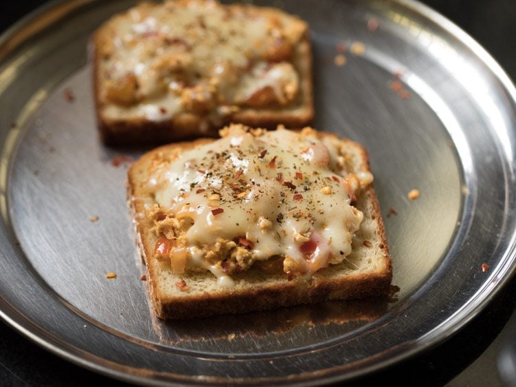 cooked paneer cheese toast on a steel plate. 