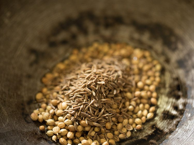 coriander seeds and cumin seeds added to hot oil in a heavy pan. 