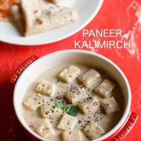 paneer kali mirch garnished with mint leaves and crushed black pepper and served in a red ceramic casserole with a plate of chapattis kept on the top left side and text layovers.