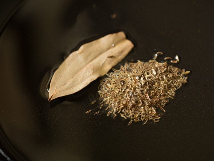 bay leaves and caraway seeds added to hot oil in pan. 