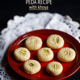 7 peda pieces on a red plate placed on white doilies.