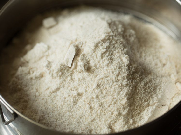 sifting ground rice flour using a sieve. 