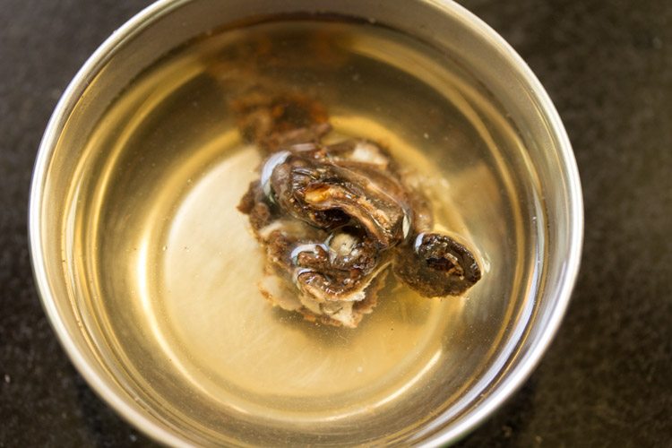 soaking tightly packed tamarind in hot water. 