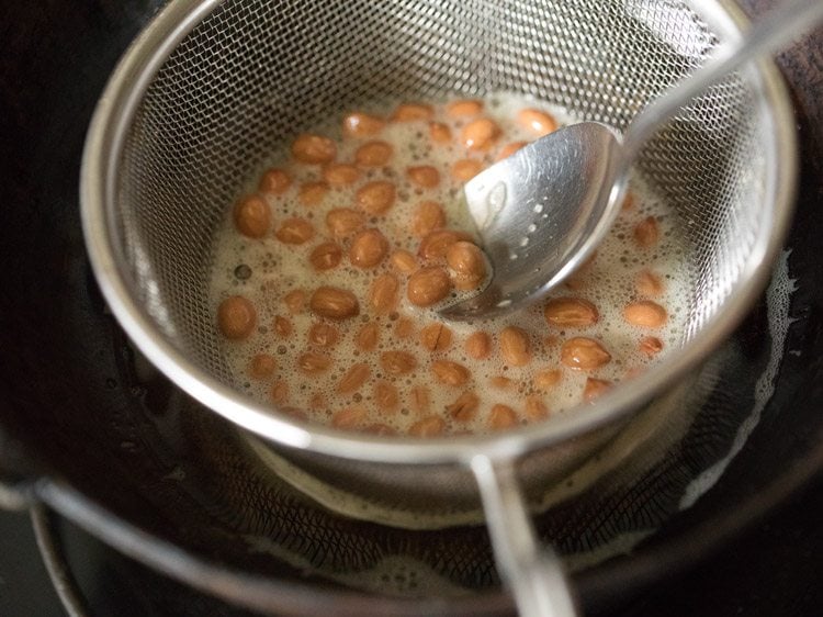 stirring peanuts to fry evenly. 