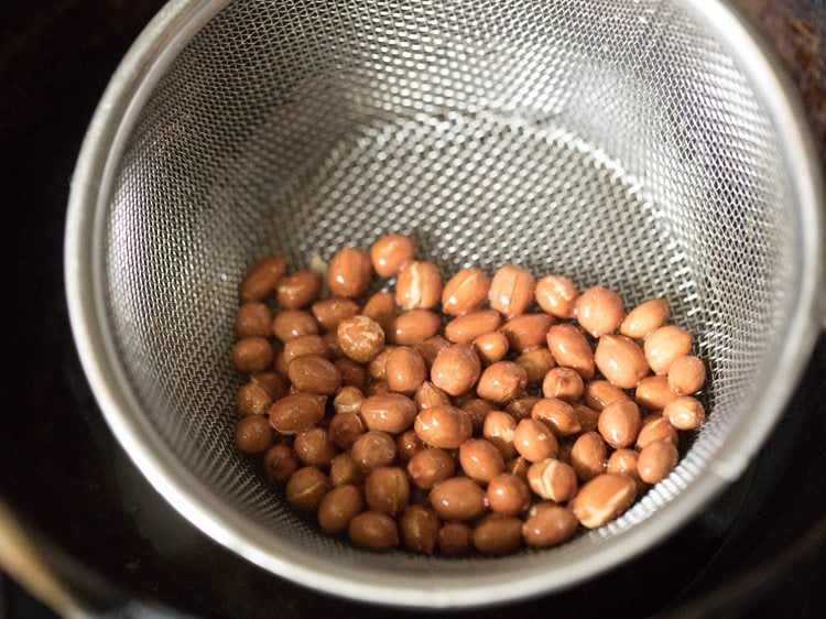 fried peanuts in fine sieve ladle. 