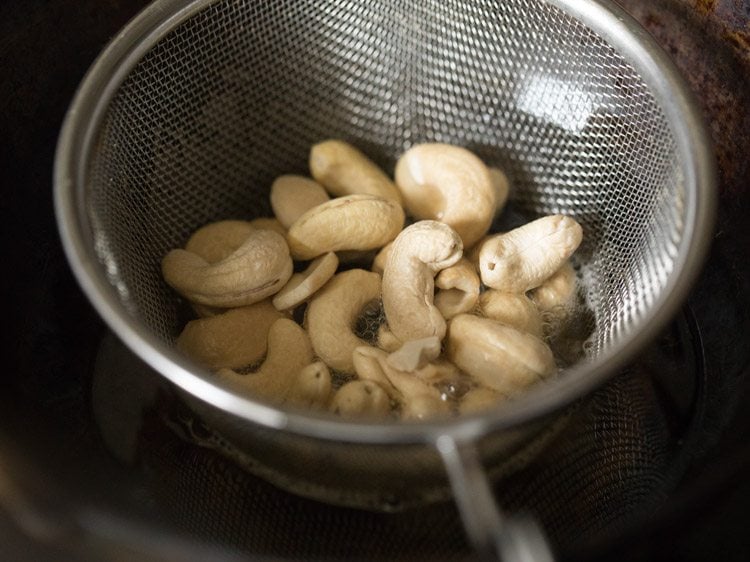cashews added in the fine sieve ladle to fry. 