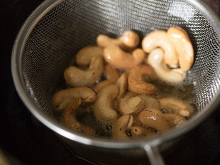 frying cashews in sieve ladle till golden. 