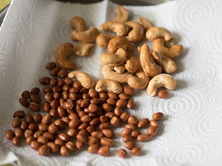 fried cashews kept with fried peanuts on kitchen paper towels. 