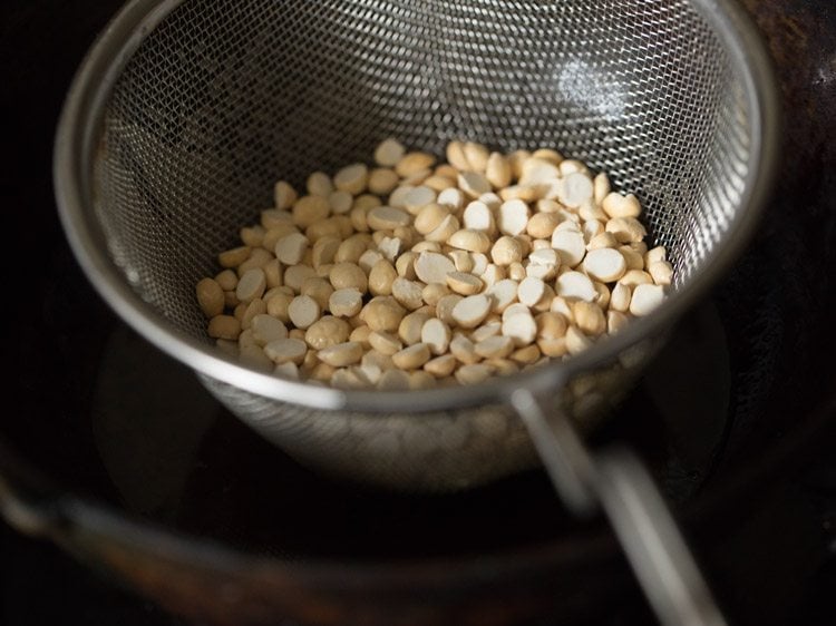 roasted chana dal added in fine sieve ladle to fry. 