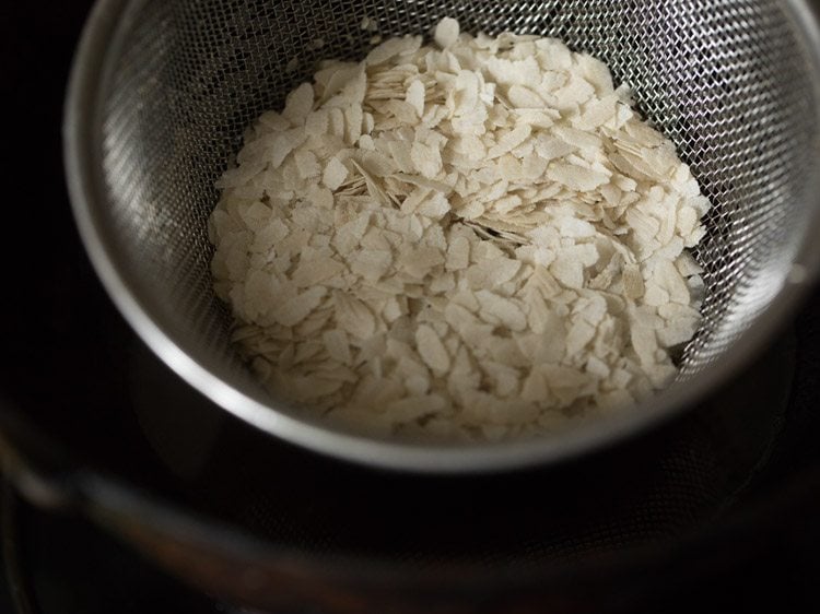 thick poha added to fine sieve ladle to fry. 