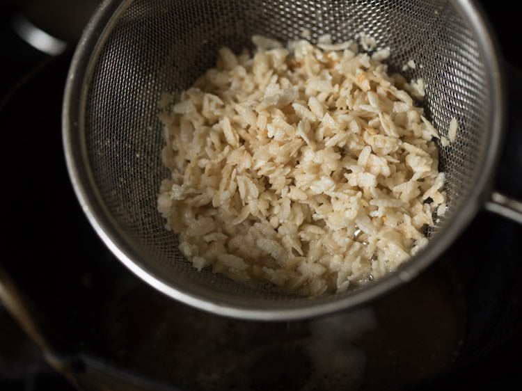 fried poha in sieve ladle. 