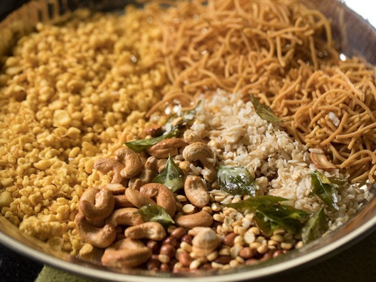 fried poha, fried chana dal, fried peanuts and fried cashews added in the plate. 