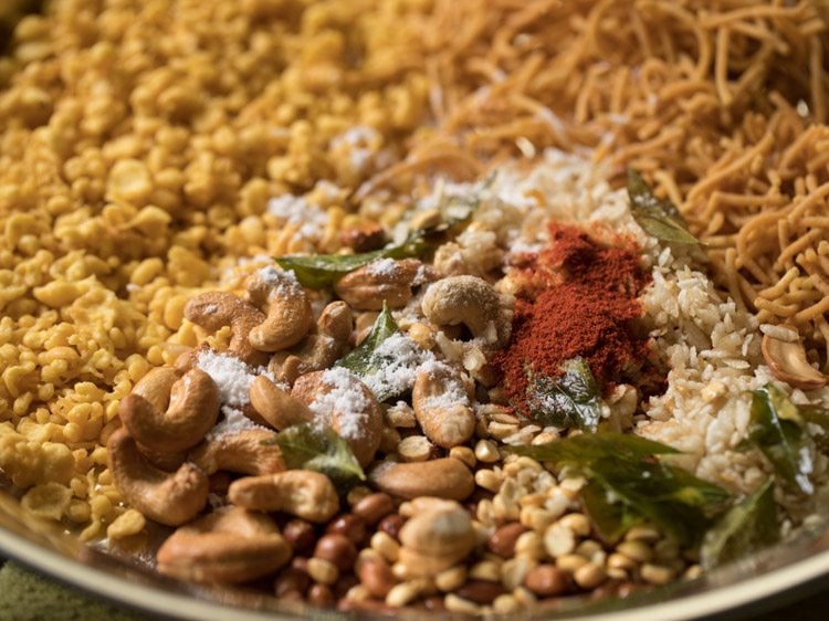 red chili powder, asafoetida and salt added over fried cashews, poha, curry leaves and peanuts. 