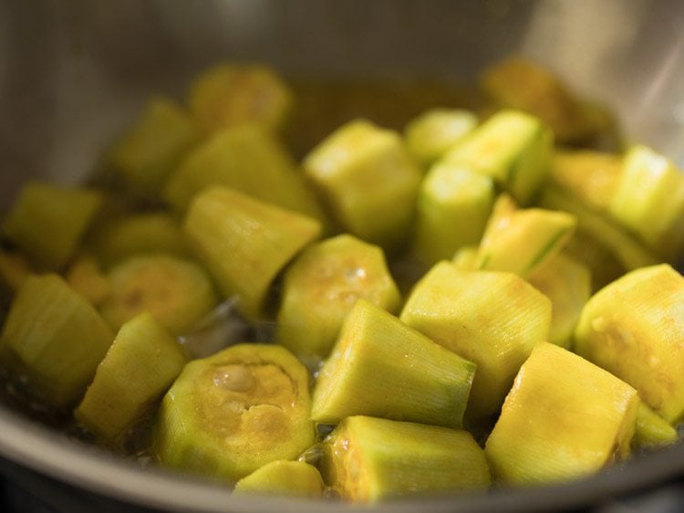 pointed gourd pieces added to the hot mustard oil. 