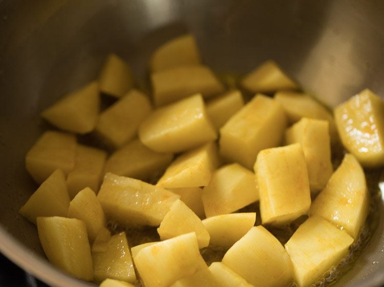 potato cubes added in hot mustard oil in the same pan. 