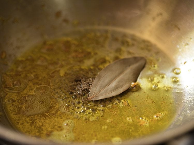 bay leaf and cumin seeds added in the hot mustard oil in the same pan. 