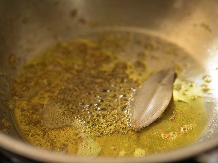 cumin seeds spluttering in hot mustard oil. 