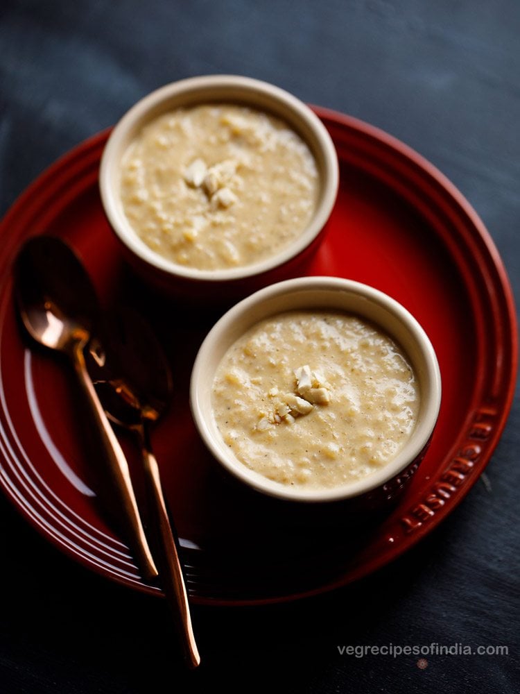 nolen gurer payesh garnished with chopped cashews served in 2 bowls with 2 spoons kept on the left side and text layover. 