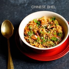 chinese bhel served in a red ceramic bowl placed on a red plate with a spoon kept on the left side and text layover.
