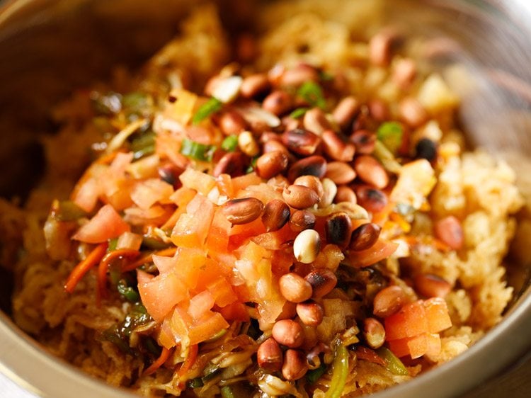 finely chopped tomatoes and roasted peanuts added to bowl. 