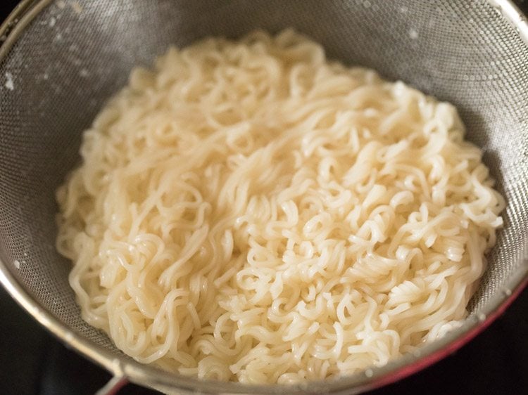 straining cooked noodles in a colander. 