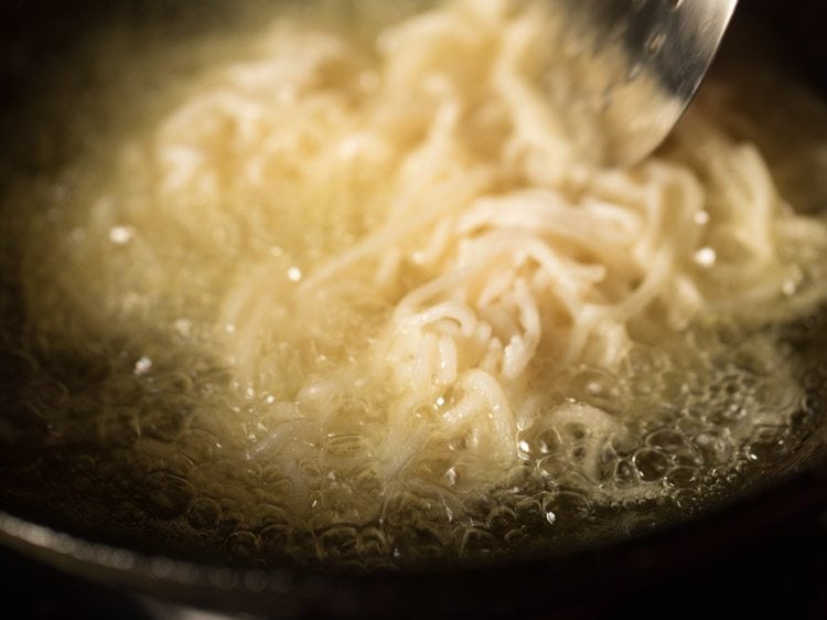 separating noodles with a spoon. 