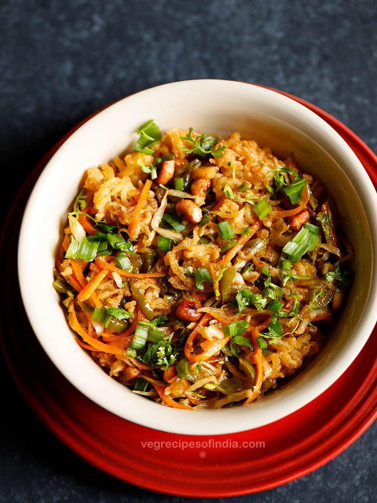 chinese bhel garnished with chopped spring onion greens and chopped coriander leaves and served in a ceramic bowl placed on a red plate. 