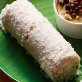 puttu served on a green colored plate with a bowl of black chickpea curry kept on the side.