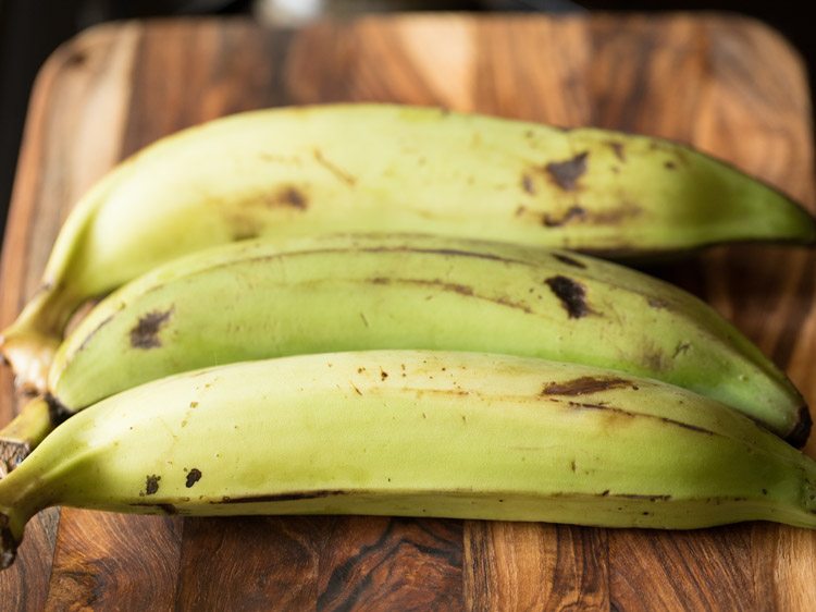 nendran bananas placed on a chopping board for kerala style banana chips recipe.