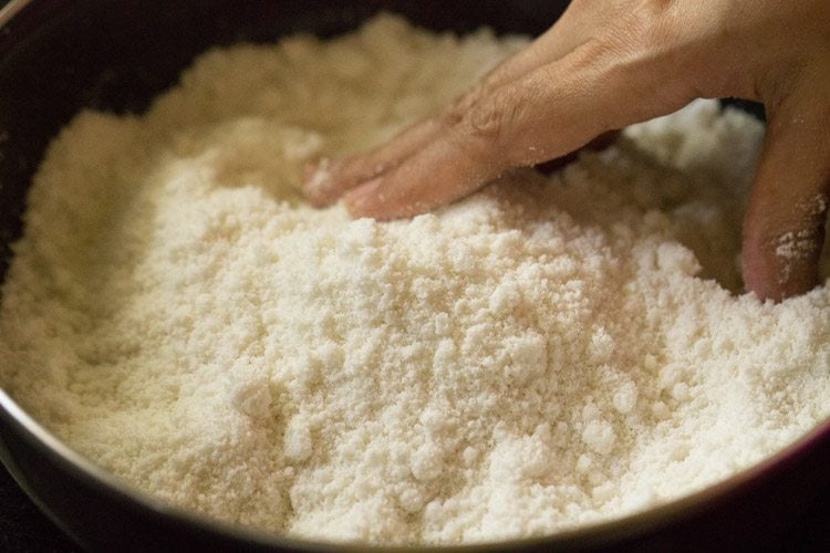 mixing water into the puttu flour with fingertips. 