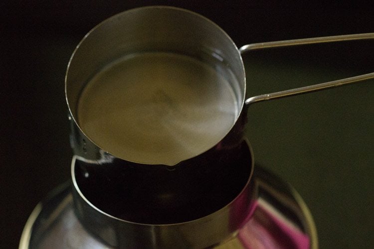 pouring water in the base vessel of puttu kudam. 