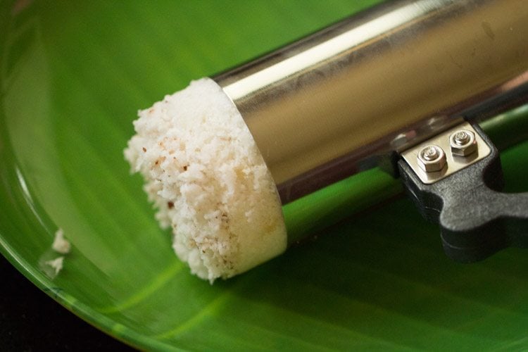 removing steamed puttu from the kudam. 