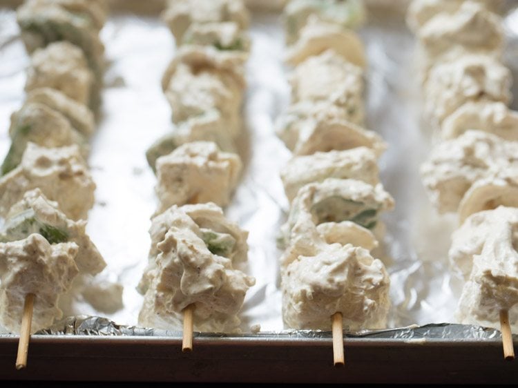 marinated paneer, onion and capsicum skewered onto bamboo sticks and placed on an aluminium foil lined baking tray. 