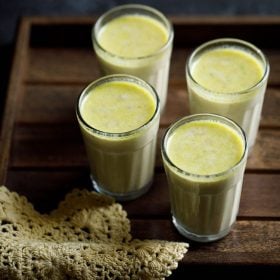 masala milk served in 4 glasses with text layovers.