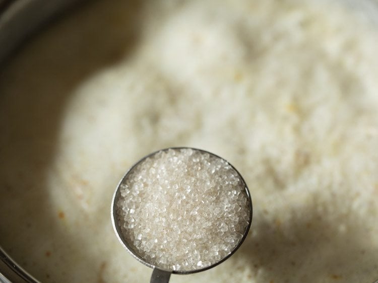 adding sugar to boiling milk. 