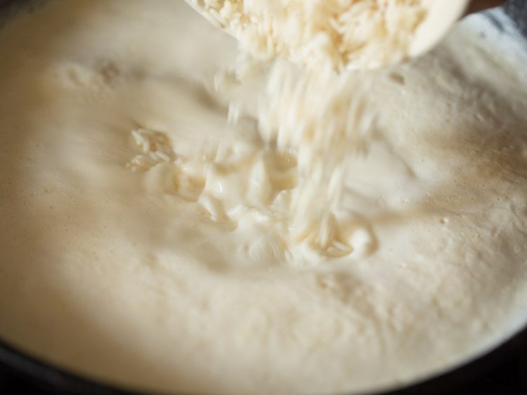 adding drained rice to the boiling milk. 