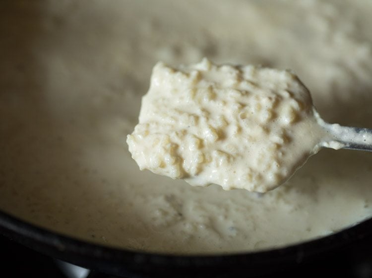 simmering the milk-rice mixture well for nolen gurer payesh. 