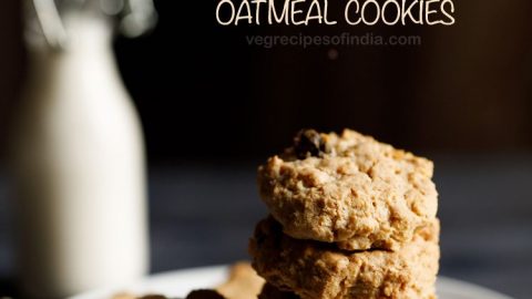 single oatmeal cookies kept on a white plate on a cream napkin with a small glass bottle of milk in the background