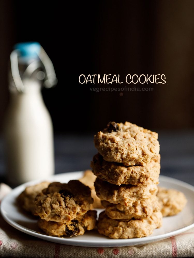 single oatmeal cookies kept on a white plate on a cream napkin with a small glass bottle of milk in the background