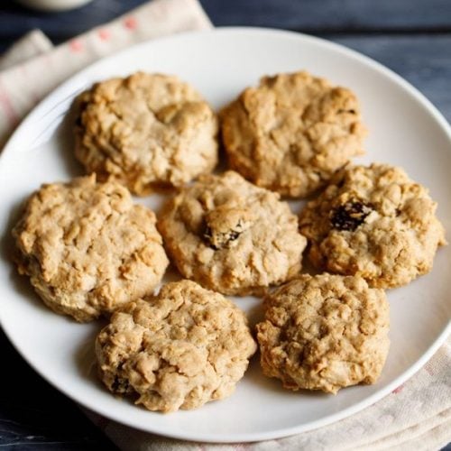 single oatmeal cookies kept on a white plate on a cream napkin