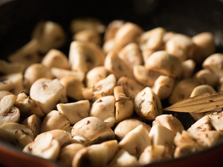 mixing mushrooms with masala