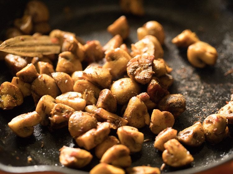 mixing mushrooms with spices and masala