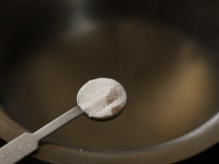 ½ teaspoon of salt being added to water.
