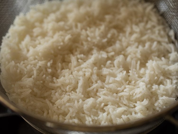 Cooked rice in a strainer.