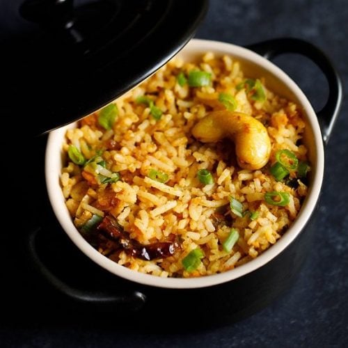 singapore fried rice in a small black pan with lid partially closed.