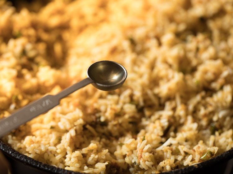 1/2 teaspoon of white vinegar being added to Singapore fried rice.