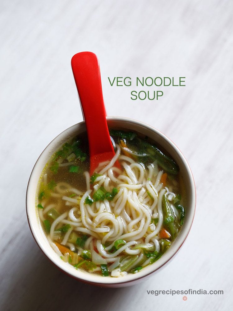 noodle soup served in a ceramic bowl with a red soup spoon in it and text layovers.