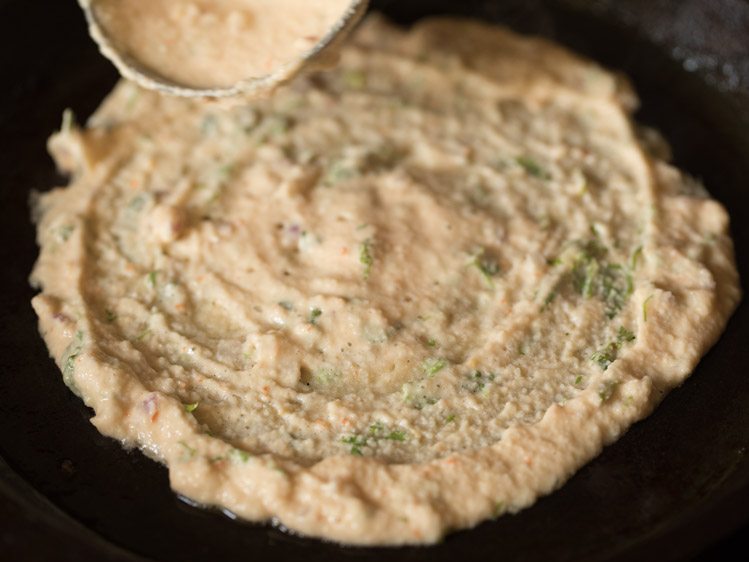 batter spread into a circle for adai recipe. 